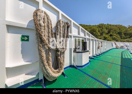Close-up of a mooring rope with  cleat. Nautical mooring rope on bow of ferry ship. Stock Photo