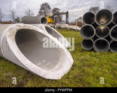 Concrete pipes and plastic draines with other building material on a construction site Stock Photo