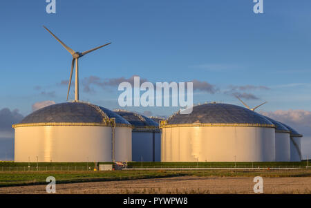 Giant modern oil storage tanks in an industrial harbor area with blue sky in the Netherlands Stock Photo
