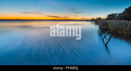 Long exposure image of Beautiful Sunset over Schildmeer near Appingedam in the Netherlands. With trails of wind in water. Stock Photo