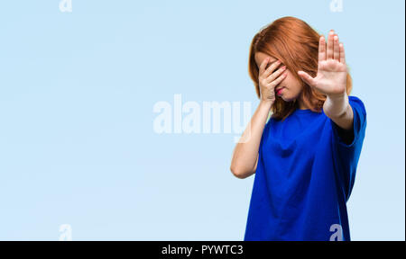 Young beautiful woman over isolated background covering eyes with hands and doing stop gesture with sad and fear expression. Embarrassed and negative  Stock Photo