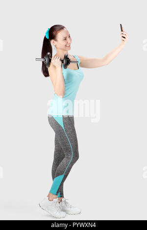 Fitness sports woman holding dumbbell and taking selfie Stock Photo