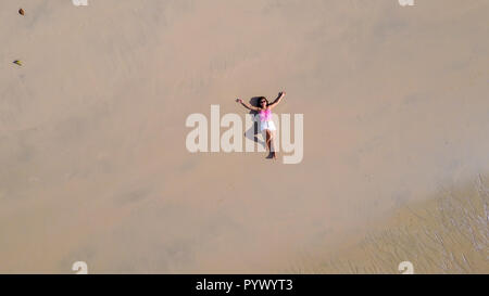 top aerial view of a woman lying on a tropical beach sand Stock Photo