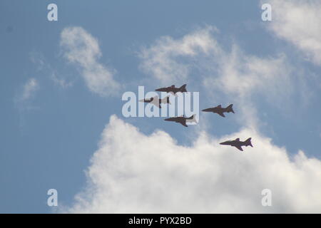 Red Arrows flying in formation through blue skies with fluffy clouds Stock Photo