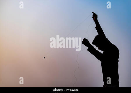 Silhouette of boy flying kite Stock Photo