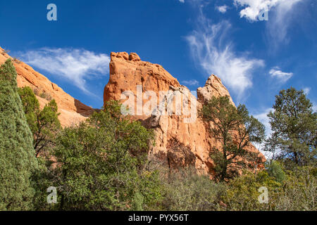 Garden of the Gods in Colorado Springs - huge red rock bluffs jut upwards against dramatic blue sky with whispy clouds Stock Photo