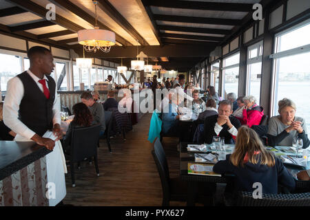 Swakopmund Namibia; A waiter waiting on people eating in the interior of The Jetty restaurant, Swakopmund, Namibia Africa Stock Photo