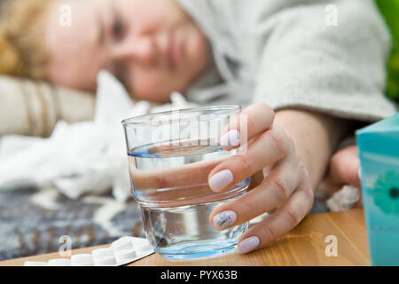 Sick and tired young woman lying on bed, closeup Stock Photo