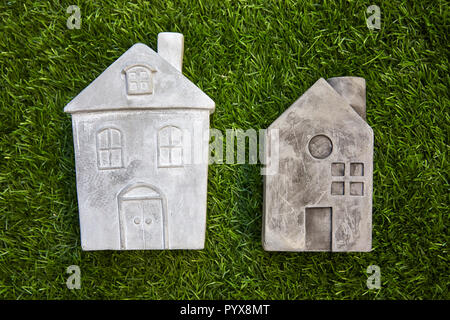 From the above shot of a few small stone houses lying on artificial green grass Stock Photo