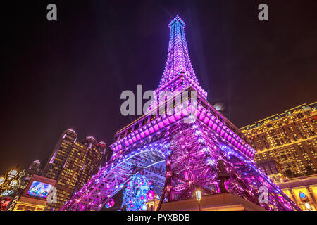 Macau, China - December 8, 2016: Perspective violet Macau Eiffel Tower, The Parisian luxury Hotel Casino of Cotai Strip, shines bright at night in the laser show. Stock Photo