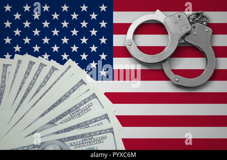 United States of America flag  with handcuffs and a bundle of dollars. The concept of illegal banking operations in US currency. Stock Photo