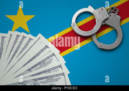 Democratic Republic of the Congo flag  with handcuffs and a bundle of dollars. The concept of illegal banking operations in US currency. Stock Photo