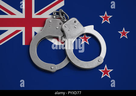 New Zealand flag  and police handcuffs. The concept of observance of the law in the country and protection from crime. Stock Photo