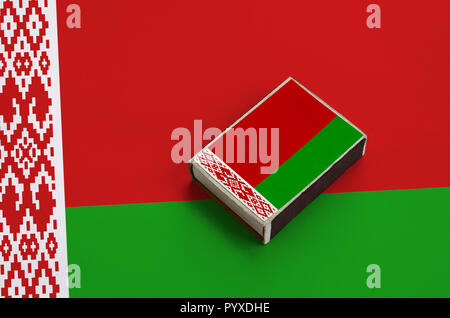 Belarus flag  is pictured on a matchbox that lies on a large flag. Stock Photo