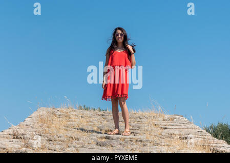 Girl in red dress standing on ancient bridge Stock Photo