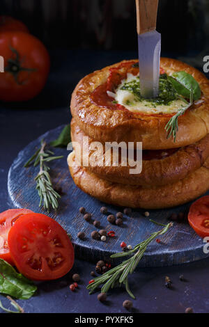 Three Homemade Mini Pizza with Tomatoes, Cheese and Bacon, Injuries and Spices on Light Blue Background Vertical Stock Photo