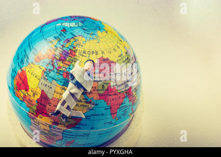 Tiny figurine of man  model wrapped in bandages  on earth Stock Photo