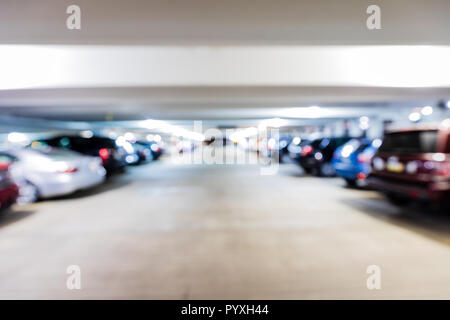Out of focus parking garage with cars and trucks parked in all of the parking spaces. Stock Photo