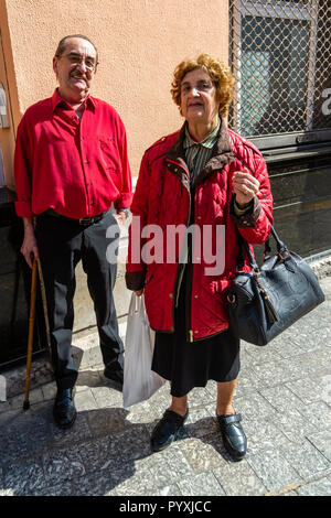 Elderly Spain couple both wearing matching red clothing Stock Photo