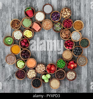 Health food for fitness concept forming a wheel including fresh fruit, vegetables, supplement powders, legumes, herbs, grains and cereals. Super foods Stock Photo