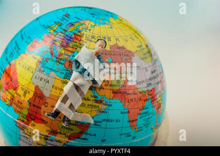 Tiny figurine of man  model wrapped in bandages  on earth Stock Photo