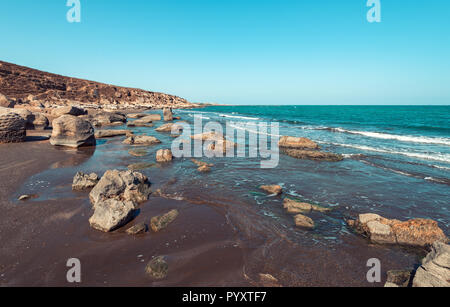Rocky sea coast with turquoise water on the beach Stock Photo