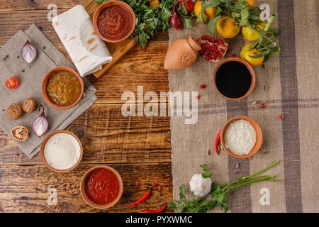 A set of sauces and condiments in ceramic cups top view. Place under your text. Stock Photo