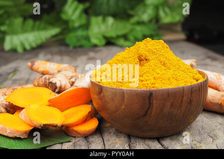Turmeric powder in wood bowls on old wooden table. Herbs Stock Photo
