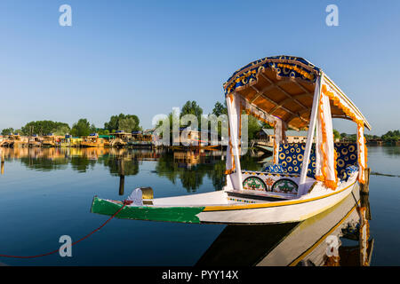 Shikaras are the common transport for people and goods on Dal Lake. Houseboats for rent are seen in the background Stock Photo