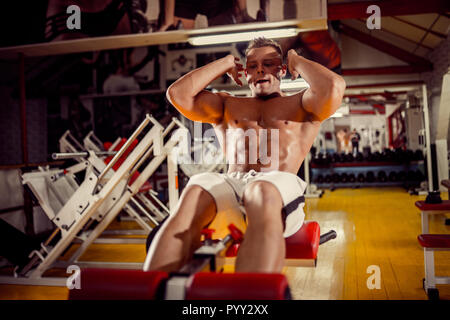 sport, fitness, bodybuilding, lifestyle and people concept - young man doing sit-up abdominal exercises Bench Press in gym Stock Photo