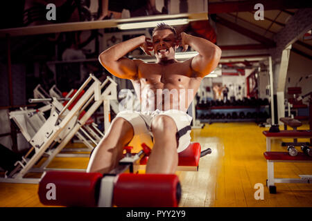sport, fitness, bodybuilding, lifestyle and people concept - young man doing sit-up abdominal exercises Bench Press in gym Stock Photo