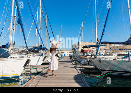 Traveling tourist woman on sightseeing tour in Heraklion Crete. Lovely elegant girl visiting the famous Mediterranean Venetian port. Fortress Rocca A  Stock Photo