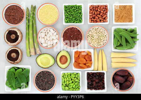 Protein plant health food selection for a healthy diet with grain, legumes, dried fruit, seeds, nuts and vegetables on rustic wood background. Stock Photo