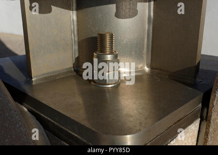 Stainless steel anchor bolt and nuts securing welded and fabricated stainless steel wind turbine mounting on Cleveleys promenade in lancashire uk Stock Photo