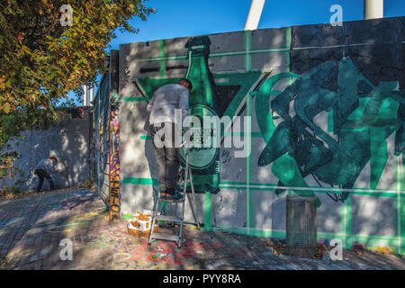 Germany,Berlin,Mauerpark. 21st October 2018. Street artists redorate the historic strip of Berlin Wall. On possibly the last warm Autumn weekend Stock Photo
