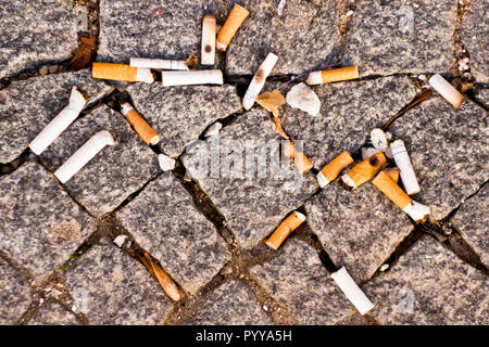 bunch of cigarette butts littering the street, view from above Stock Photo