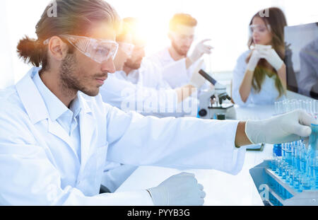Scientists working with a microscope and make notes in the workplace Stock Photo