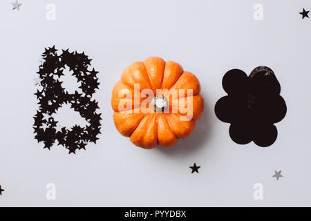 Word Boo is made from little pumpkin, silver stars confetti and black decor. Halloween party concept. Flat lay style. Top view. Stock Photo