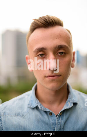 Face of young handsome man outdoors in city Stock Photo