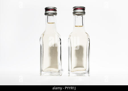 Two bottles of vintage alcohol with shadows in the shape of the heads of two young men. Stock Photo