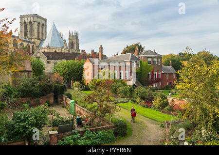 Scenic view of historic buildings from city walls - Grays Court (gardener working) Minster & Treasurer's House - York, North Yorkshire, England, UK. Stock Photo