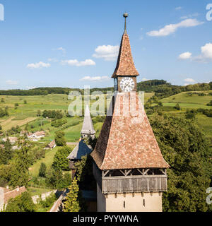 Biertan town and Biertan lutheran evangelical fortified church spires and clock tower. Transylvania, Romania. Aerial close up view. Biserica fortificata din Biertan, Sibiu, Transilvania, Romania Stock Photo