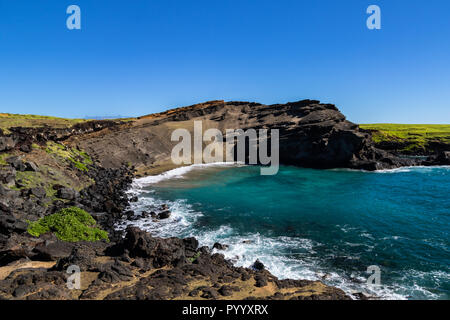 Green sand beach (papakolea) near South Point on Hawaii's Big Island. Beach is at the bottom of the steep slope; rocky shoreline is in foreground. Stock Photo