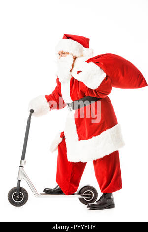 side view of santa claus with sack riding scooter isolated on white Stock Photo