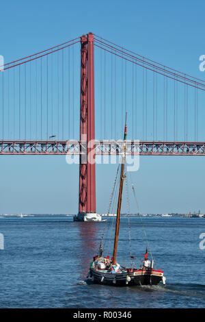 Sightseeing boats on the Tagus River (Rio Tejo) with the Ponte 25 de Abril suspension bridge, Lisbon, Portugal. Stock Photo