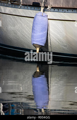 a sailing boats fender reflecting on calm waters Stock Photo