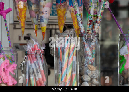 various Seaside sticks of rock and sweets for sale in jars at the beach Stock Photo