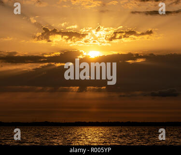 light rays shining through clouds at the coastline Stock Photo