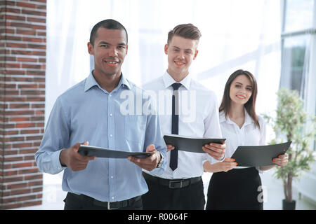 business team standing with documents on the background of the office. Stock Photo