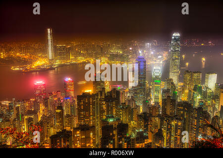 Aerial view of Victoria Harbour skyline by night from Lugard Road Lookout at Victoria Peak, the highest mountain in Hong Kong Island. Business skyscrapers with their lights and neon. Stock Photo